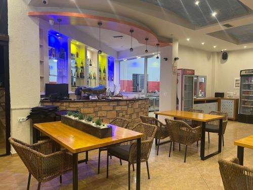 卡萨米尔Hotel Ronaldo的一间带桌椅的餐厅和一间酒吧
