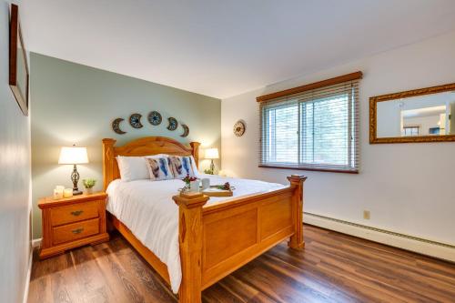 埃斯蒂斯帕克Estes Park Condo Rental Balcony with River Views!的一间卧室设有一张木床和一个窗户。
