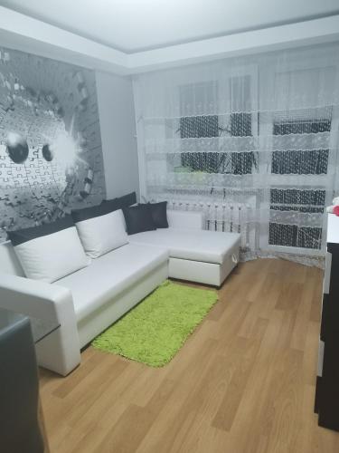 戈尔利采Vip apart的客厅配有白色沙发和绿色地毯。