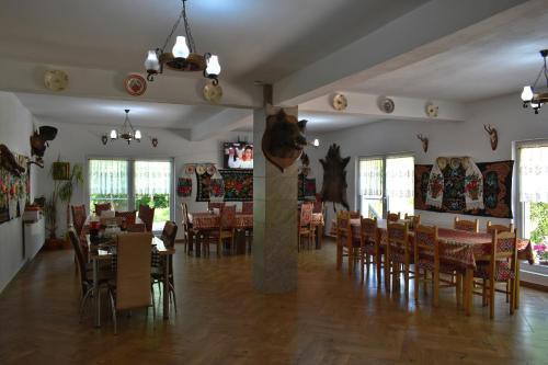 瓦杜伊泽Casa Papițu的一间在房间内配有桌椅的餐厅