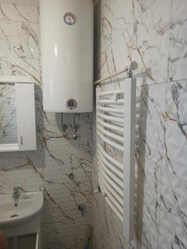 乌日策stan na dan IM的一间带水槽和白色橱柜的浴室