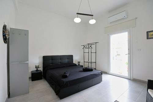 拉卡莱Salentuosi Camere的一间卧室设有一张黑色的床和一个窗户。