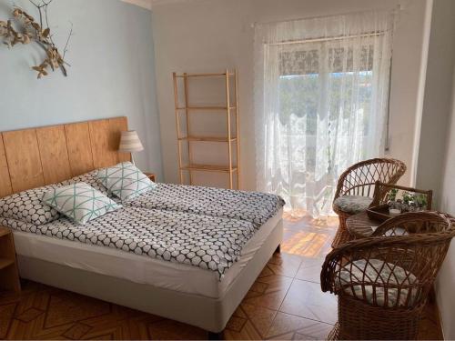 Carvalheira GrandeCasa da Rosa的一间卧室配有一张床、两把椅子和一个窗户