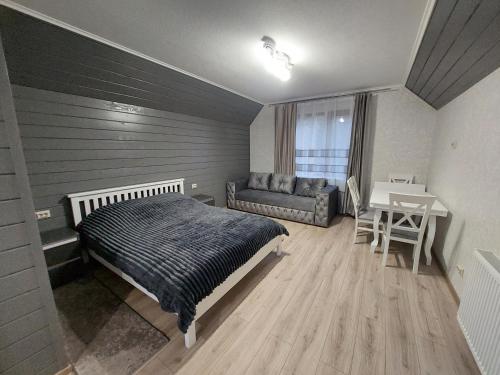 沃罗赫塔Котедж у Ліску 2的一间卧室配有一张床、一张桌子和一张沙发