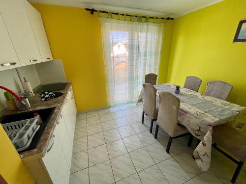 罗戈兹尼察Apartments Mikulić的厨房设有餐桌和黄色的墙壁