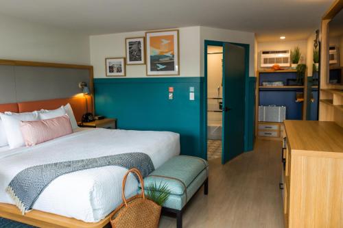 西雅茅斯Freebird Motor Lodge by Reverie Boutique Collection的一间卧室设有一张床和蓝色的墙壁