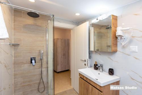 帕莱欧卡斯提撒Matsas House & Studio的带淋浴、盥洗盆和镜子的浴室