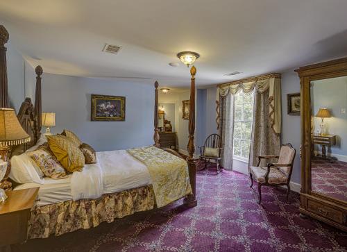 维克斯堡The Inn at Cedar Grove的一间卧室配有一张大床,铺有紫色地毯