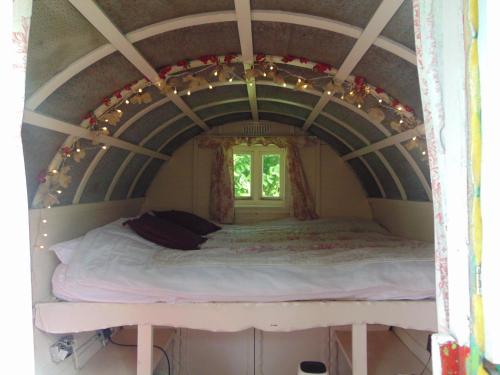 兰达西尔Romany Wagon & Cwtch的一个小房间的一个床位,设有窗户
