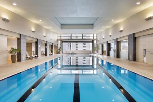 奥克兰Pullman Auckland Hotel & Apartments的大楼内的一个蓝色海水游泳池