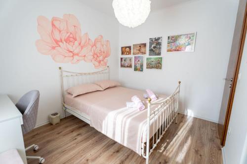 Široki BrijegHoliday home Carpinus的卧室配有一张墙上的带粉红色鲜花的婴儿床。