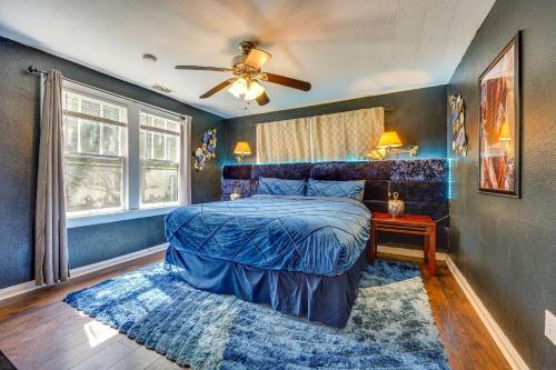 杰克逊维尔Jacksonville Vacation Rental with Deck!的蓝色卧室配有床和吊扇
