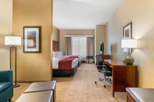 福雷斯特城福雷斯特城康福特套房酒店的配有一张床和一张书桌的酒店客房