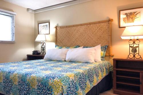 科洛阿Kuhio Shores 416的一间卧室配有一张蓝色和黄色的床罩
