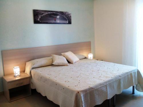托里切拉B&B Trullo di Mare的一间卧室配有一张带两盏灯的床。