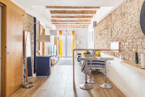 略夫雷加特河畔奥斯皮塔莱特Sweet Room Barcelona的厨房配有桌椅和砖墙