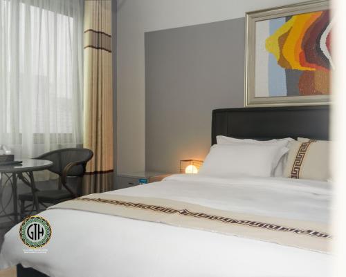 ApenkwaGullivers Travel Hotel的卧室配有白色的床和桌子
