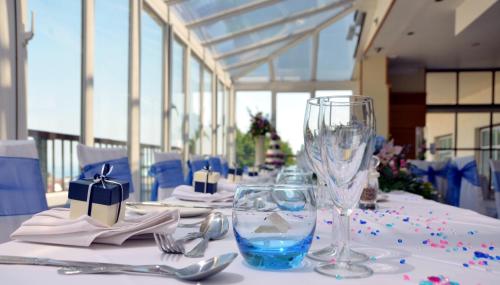 伯恩茅斯The Riviera Hotel & Apartments - Alum Chine的一张桌子,上面有白色的桌布和酒杯