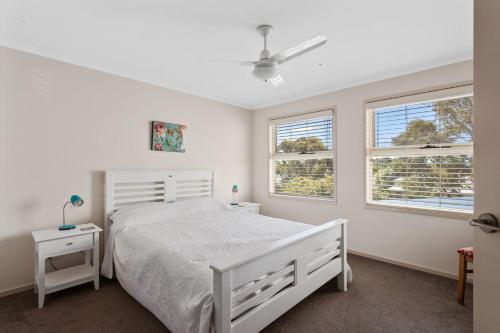 卡尔斯45 Norman Drive的卧室配有白色的床和2扇窗户。