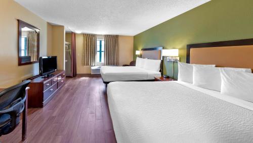 蒙哥马利Home 1 Suites Extended Stay的酒店客房设有两张床和一台平面电视。