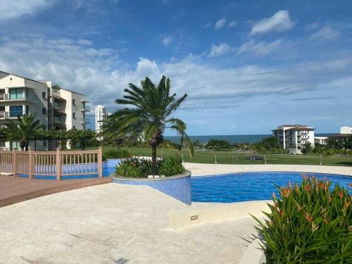 圣卡洛斯Lujoso y Familiar Apartamento de Playa y Golf en San Carlos Panamá的游泳池旁的棕榈树