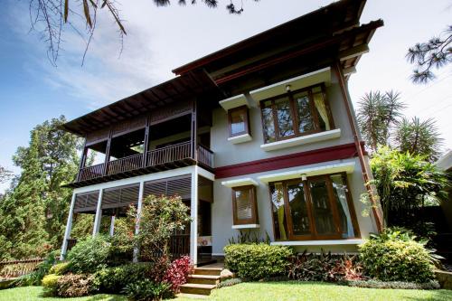 万隆Rumah Pelita near Lembang FREE WIFI - Villa Lantera的带阳台和庭院的房子