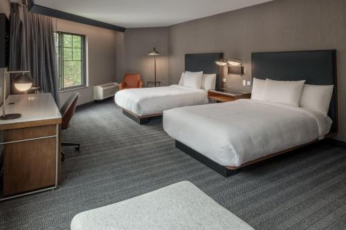 奥林匹亚Courtyard by Marriott Olympia的酒店客房配有两张床和一张书桌