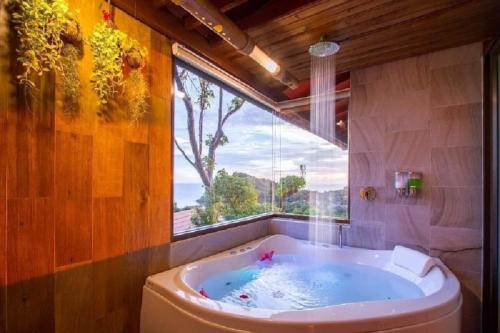 高兰Puteri Lanta Family Villas的带浴缸的浴室和大窗户