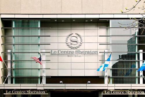 蒙特利尔蒙特利尔喜来登中心酒店的建筑一侧的标志,带有旗帜