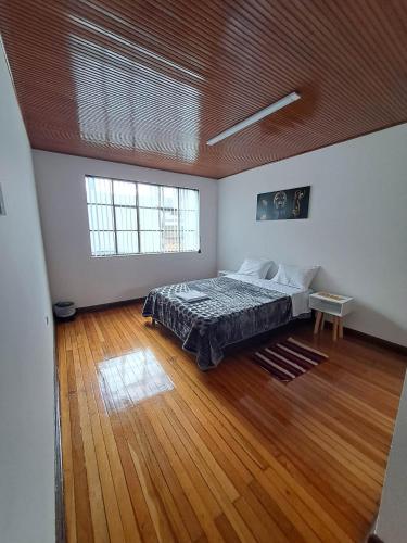 波哥大Makarena Hostel的一间铺有木地板的大卧室,配有一张床
