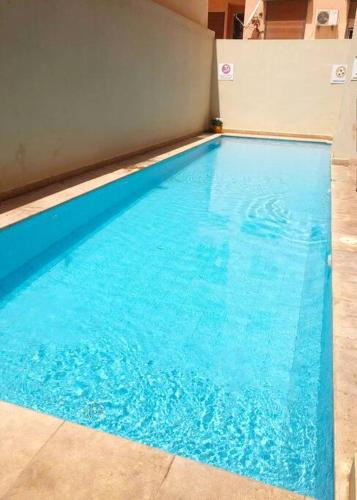 马拉喀什appartement dans résidence Marrakech avec piscine的大楼里的一个大型蓝色游泳池