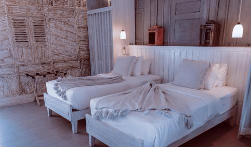 蓝梦岛Sandy Bay的一间卧室配有两张带白色床单的床