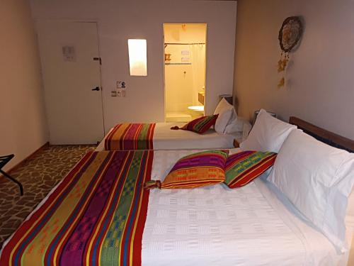 RincónHotel Casa Sattva- Bed & Breakfast的两张睡床彼此相邻,位于一个房间里