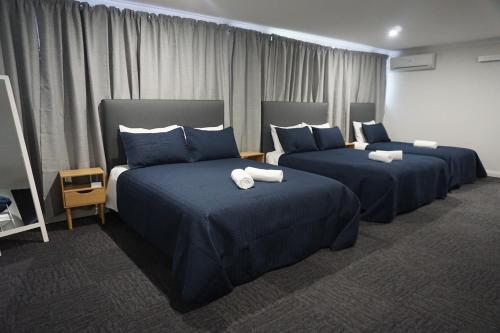 华纳海湾华纳湾酒店的酒店客房,配有两张带蓝色床单的床