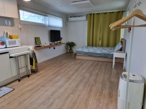 济州市Cozy House & Tour的客房设有带一张床和微波炉的卧室。