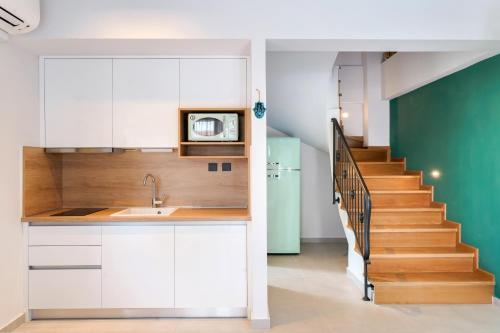 克里斯阿穆迪亚Aerino Luxury Villas的一间厨房,配有白色橱柜和楼梯