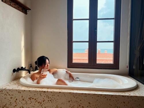 富国Lotus Home Cafe - Free Hon Thom Island Waterpark Cable Car的躺在窗户浴缸中的女人
