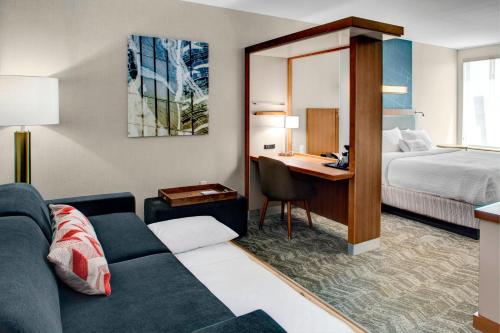 雷内克萨SpringHill Suites by Marriott Kansas City Lenexa/City Center的酒店客房配有一张床、一张沙发和一张书桌。