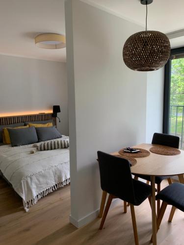 ĶesterciemsSeaside apartment Albatross, 16的卧室配有一张床和一张桌子及椅子