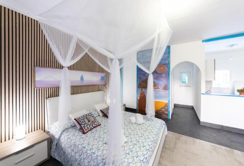 弗卡诺Holiday Eolie Village的一间卧室配有一张带天蓬的白色床