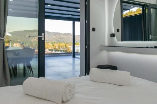 新马尔马拉斯SithoniaRS Luxury 2nd Floor Roofgarden Apartment With Unique Seaview的一间卧室设有一张床,享有阳台的景色