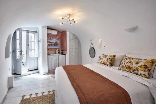 易莫洛林El Verano Hideaway的一间白色卧室,配有一张大床和一个厨房