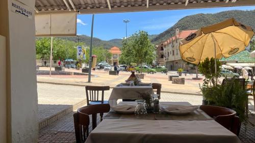 艾兹鲁Hotel des cedres,azrou maroc的街上一张带黄伞的桌子