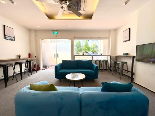 新加坡Beary Best! Hostel Chinatown的客厅配有蓝色的沙发和桌子