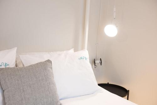 塞萨洛尼基MeYia studios的一张带白色枕头的床和灯