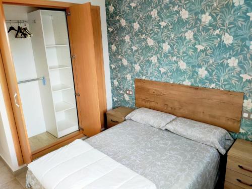圣乔治Panoramica Golf Karilo的一间卧室配有一张床和华丽的壁纸
