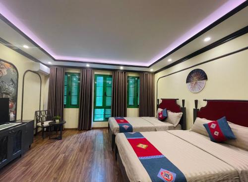 萨帕Moonlight Hotel Sa Pa的一间卧室配有两张床和一台平面电视