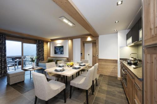 拉赫兹耶尔Residence Alpen Lodge的厨房以及带桌椅的用餐室。