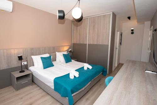 比托拉ZARO Apartments的一间卧室配有一张带蓝色和白色枕头的床