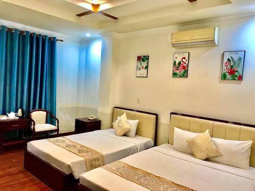 芹苴Linh Phuong 8 Hotel的酒店客房,配有两张带蓝色窗帘的床